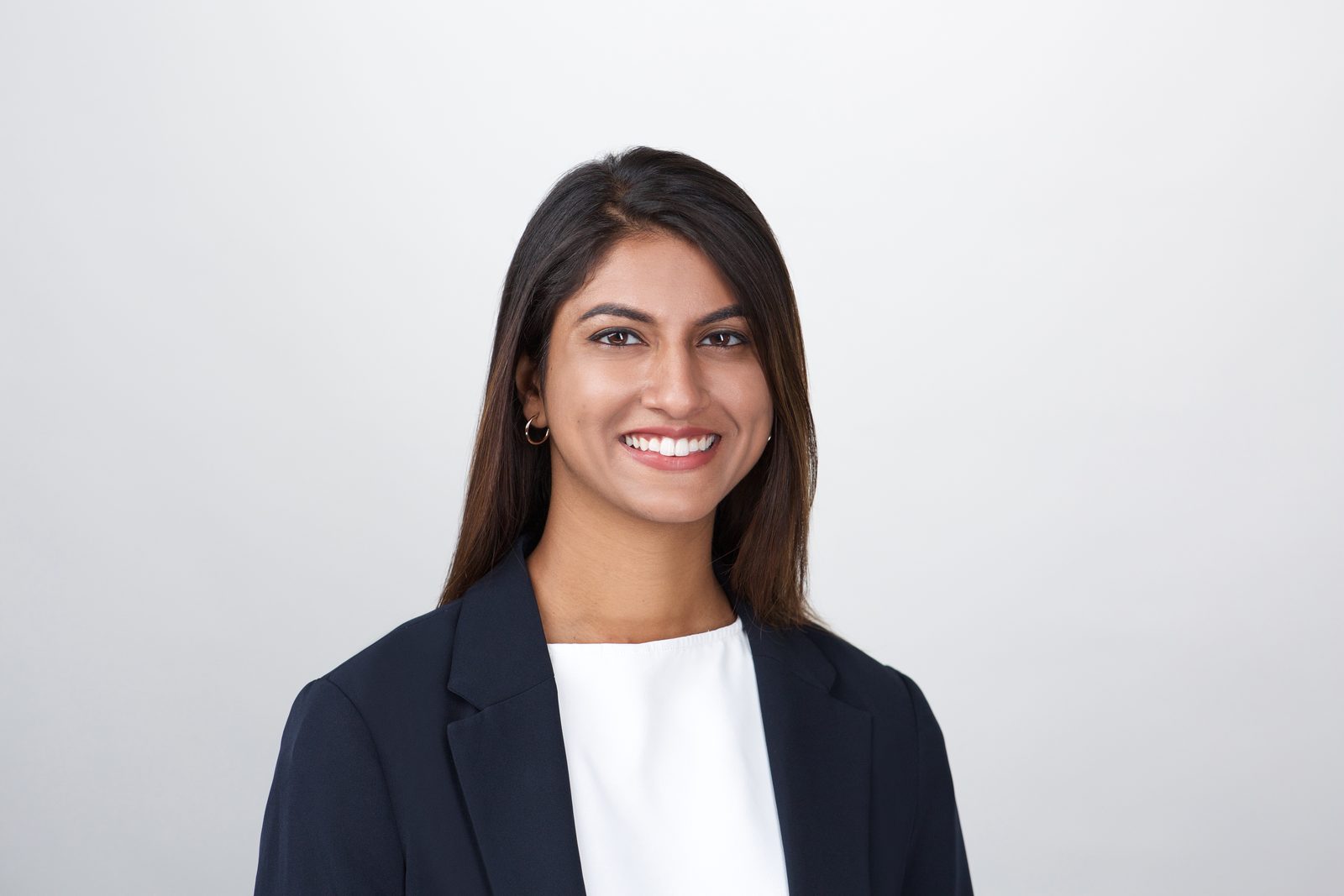 ERAS application photo — medical residency applicant in a dark blazer on a light gray studio background, New York
