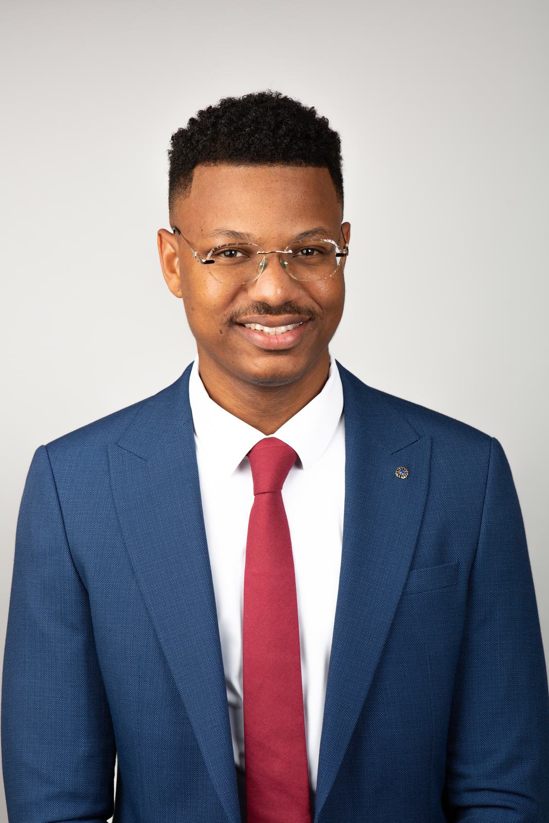 ERAS headshot — man in a blue suit with red tie and glasses, Miami studio