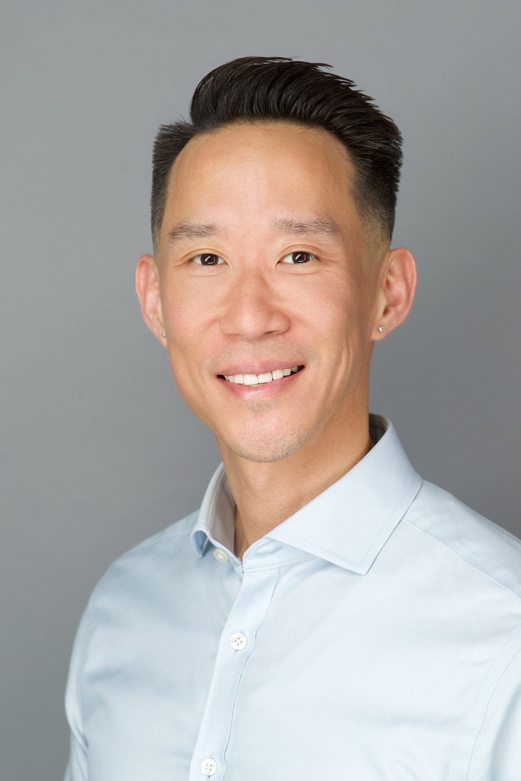 ERAS Basic session headshot — smiling man in a light blue shirt, New York studio