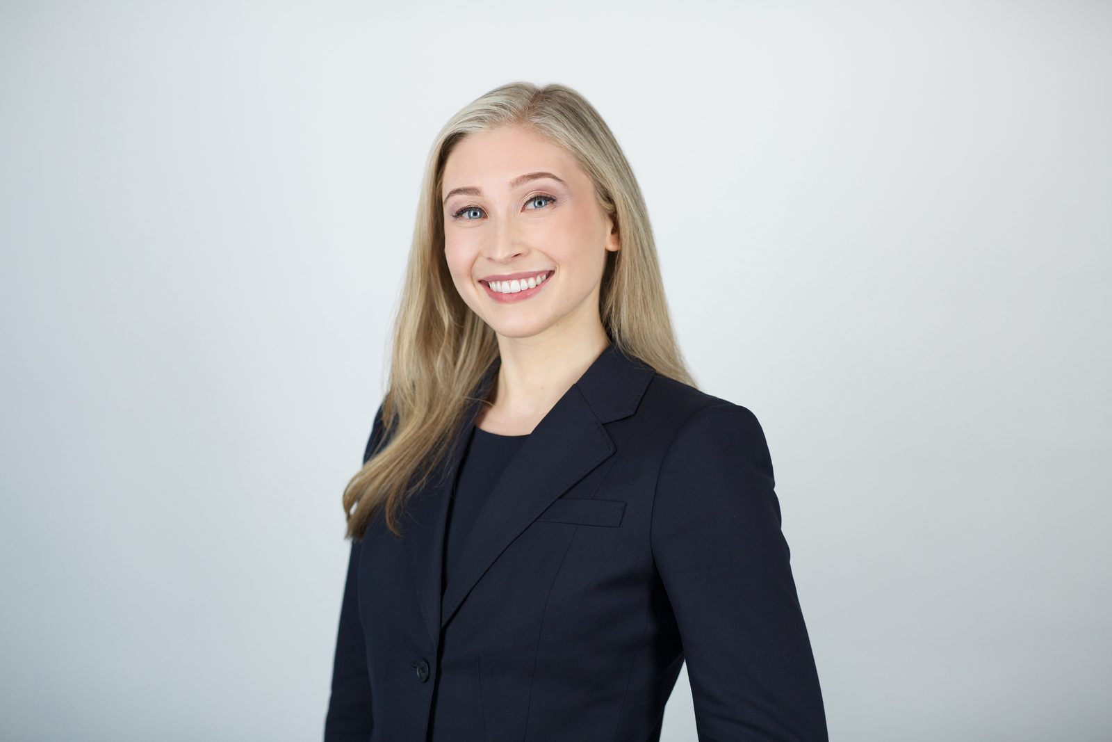 ERAS application photo — blonde woman in a dark suit, New York studio