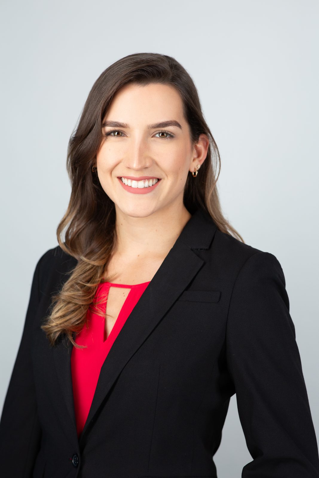 Residency headshot — woman in a black blazer over a red top, Miami